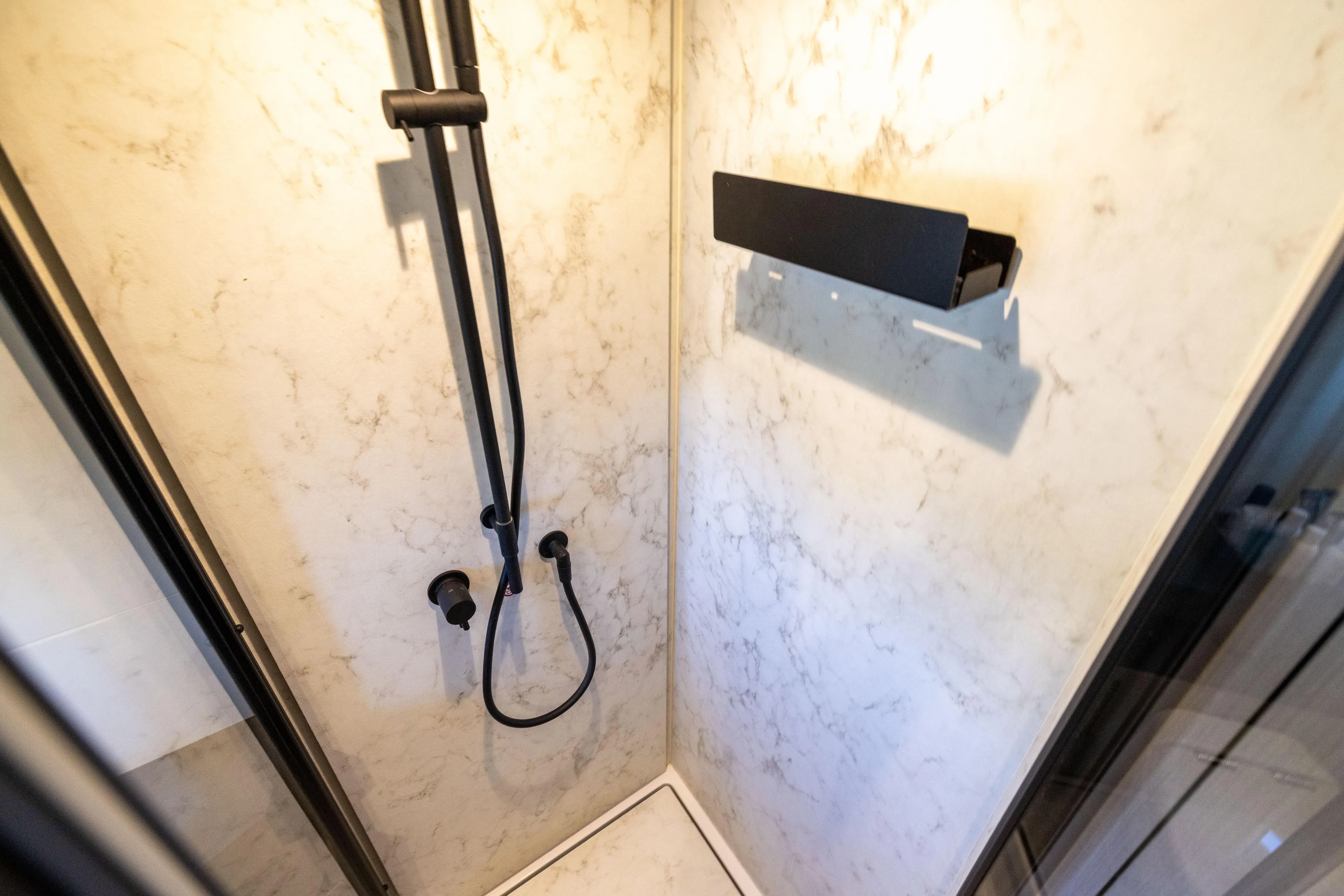 Second Chances Yacht Photos Pics Luxurious shower in 2024 Azimut S7 yacht with marble walls and modern fixtures.