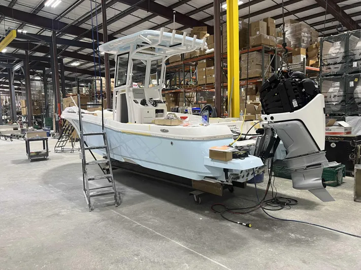 Hybrid Performance Yacht Photos Pics 2025 Caymas 24 HB boat in a warehouse, under construction with equipment and tools around.