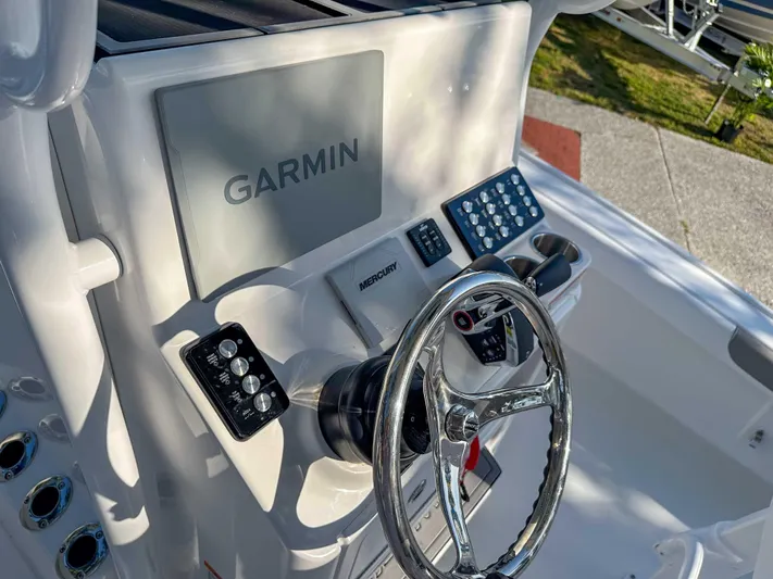 Hybrid Performance Yacht Photos Pics 2025 Caymas 24 HB boat dashboard with Garmin navigation system and steering wheel.