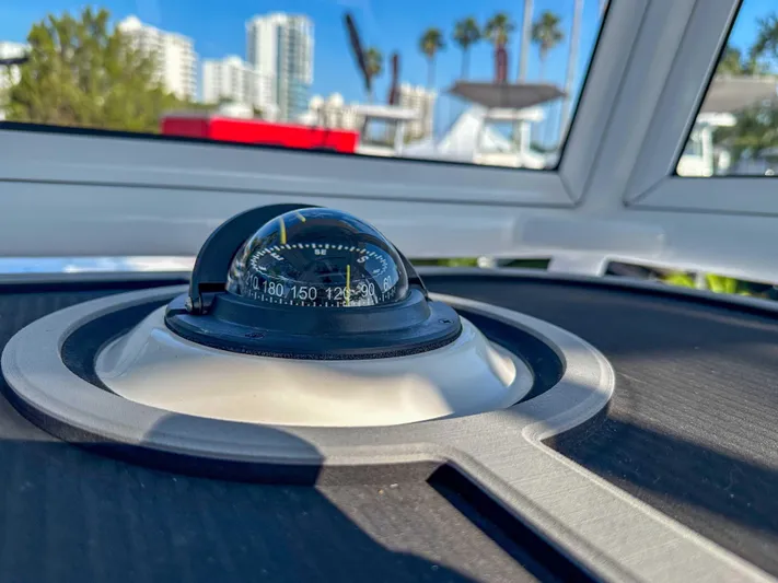 Hybrid Performance Yacht Photos Pics Compass on 2025 Caymas 24 HB boat with cityscape and palm trees in background.