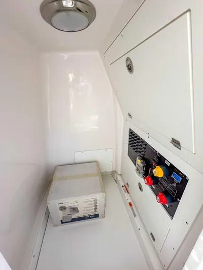 Hybrid Performance Yacht Photos Pics 2025 Caymas 24 HB boat interior compartment with electrical panel and storage.