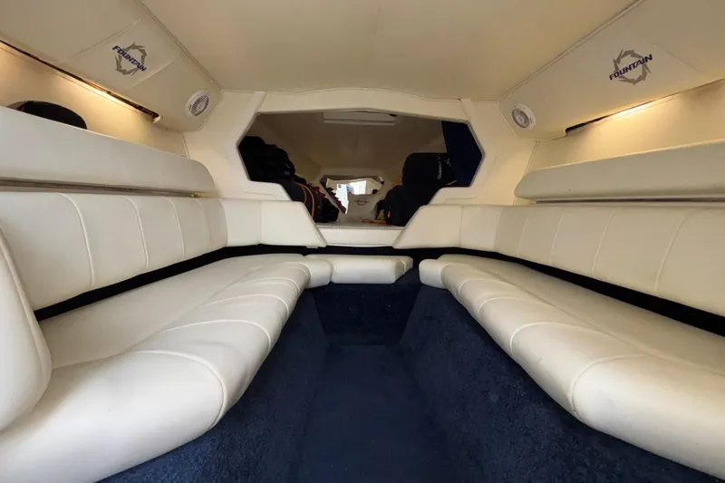  Yacht Photos Pics Interior of a 2007 Fountain 42 Lightning boat with white seating and blue carpet.