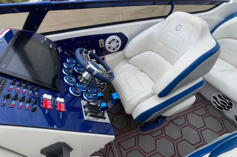  Yacht Photos Pics 2007 Fountain 42 Lightning boat cockpit with white and blue seating, control panel, and steering wheel.