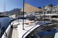 Luxurious 2019 Custom Line 106 yacht docked in a scenic marina with modern architecture.