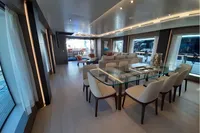Luxurious yacht interior with elegant dining area, glass table, and modern decor, Custom Line 106, 2019.