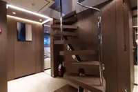 Modern interior of Custom Line 106 yacht, featuring sleek wooden spiral staircase, 2019 model.