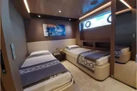 Luxurious twin bedroom on 2019 Custom Line 106 yacht, featuring modern decor and ambient lighting.