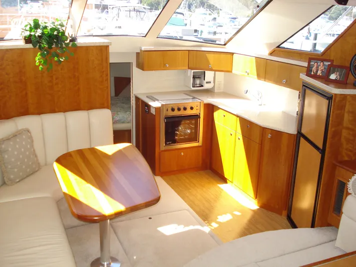 Jet Lag Yacht Photos Pics Interior of 2000 Silverton 392 Motor Yacht with kitchen and seating area.