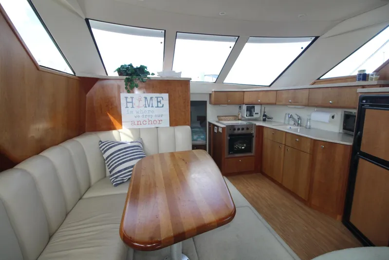Jet Lag Yacht Photos Pics Interior of 2000 Silverton 392 Motor Yacht with dining area and kitchen.