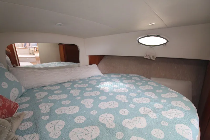 Jet Lag Yacht Photos Pics Cozy bedroom in 2000 Silverton 392 Motor Yacht with patterned bedding and porthole window.