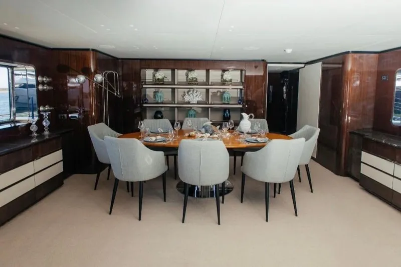 Lady In Blue Yacht Photos Pics Luxurious dining area on 1999 Clemna Rossi Navi 135 yacht, featuring elegant decor and seating.