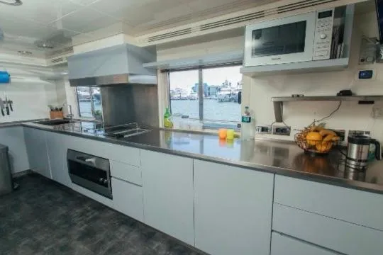 Lady In Blue Yacht Photos Pics Modern kitchen interior on Clemna Rossi Navi 135 yacht, featuring stainless steel appliances and waterfront view.