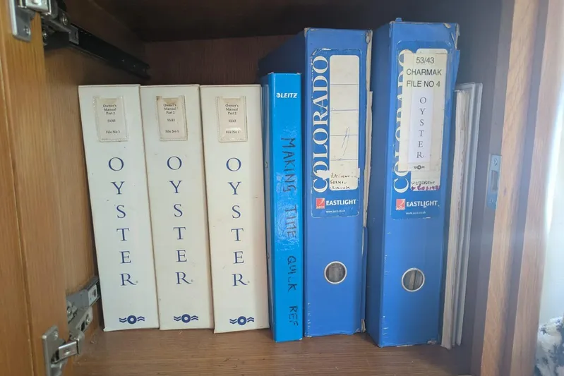 Making Time Yacht Photos Pics Binders labeled "Oyster" and "Colorado" on a wooden shelf, related to Oyster 53, 2004.