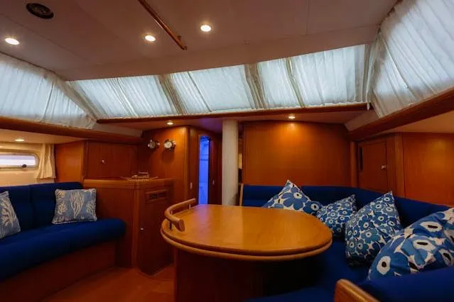 Making Time Yacht Photos Pics Luxurious interior of a 2004 Oyster 53 yacht with blue seating and wooden table.