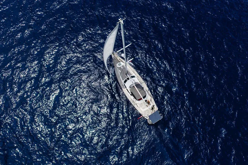 Making Time Yacht Photos Pics Aerial view of 2004 Oyster 53 sailboat navigating deep blue ocean waters.