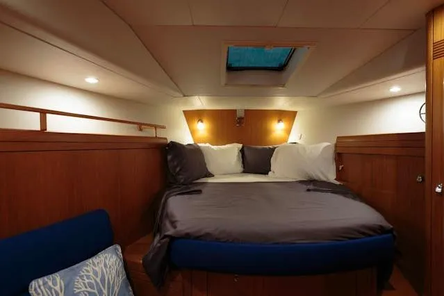 Making Time Yacht Photos Pics Luxurious cabin interior of a 2004 Oyster 53 yacht with cozy bedding and ambient lighting.