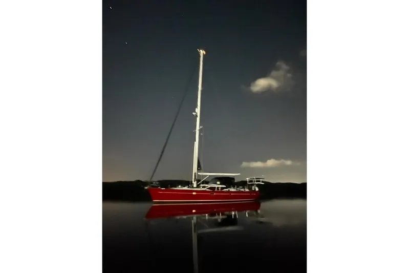 Making Time Yacht Photos Pics Red 2005 Oyster 53 sailboat anchored at night under a starry sky.