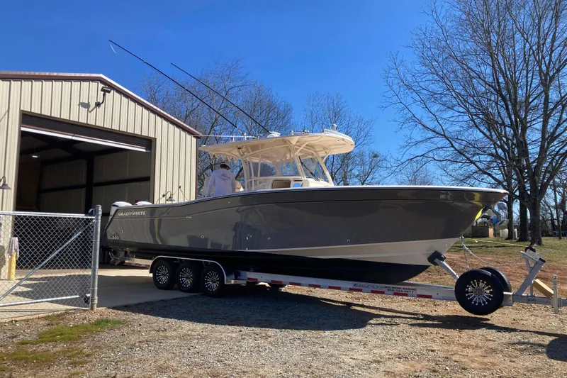  Yacht Photos Pics 2019 Grady-White Canyon 336 boat on trailer near storage building, clear sky.