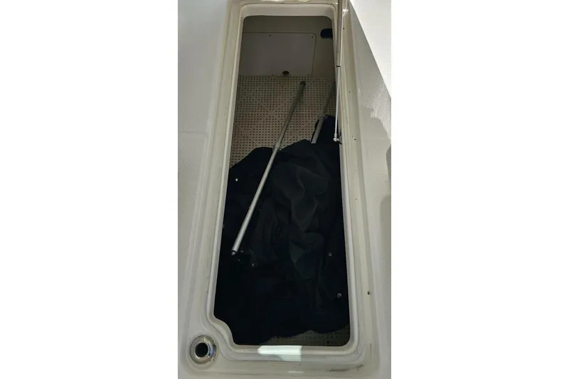  Yacht Photos Pics Storage compartment of 2018 Robalo R317 Dual Console boat with black cover and pole.
