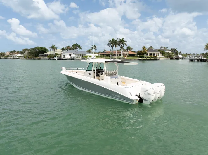  Yacht Photos Pics 2019 Boston Whaler 350 Outrage boat on calm water with palm trees in the background.