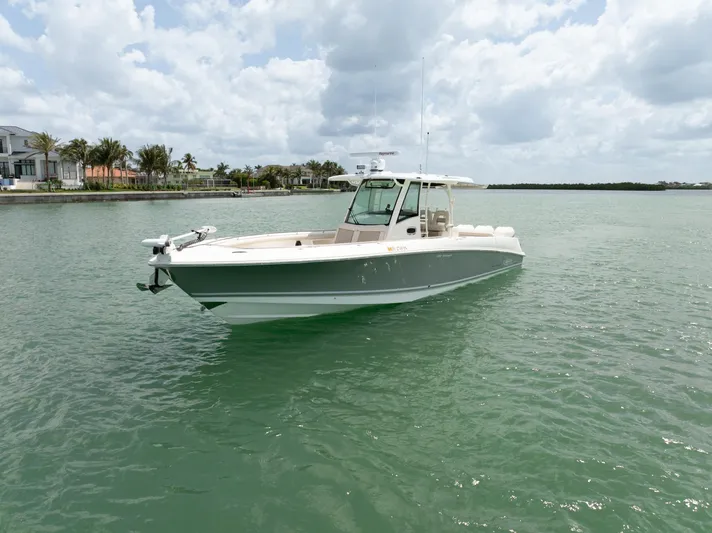  Yacht Photos Pics 2019 Boston Whaler 350 Outrage boat on calm water, under a partly cloudy sky.