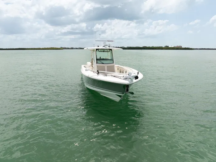  Yacht Photos Pics 2019 Boston Whaler 350 Outrage boat on calm green water under cloudy sky.
