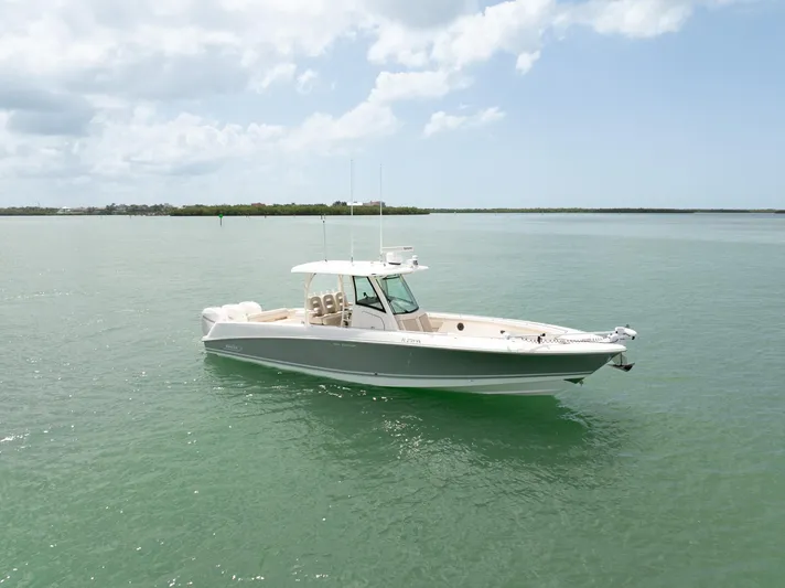  Yacht Photos Pics 2019 Boston Whaler 350 Outrage boat on calm water under a cloudy sky.