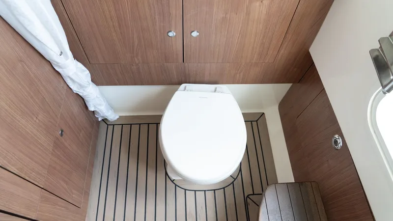  Yacht Photos Pics 2019 Boston Whaler 350 Outrage boat bathroom with wooden cabinetry and flooring.