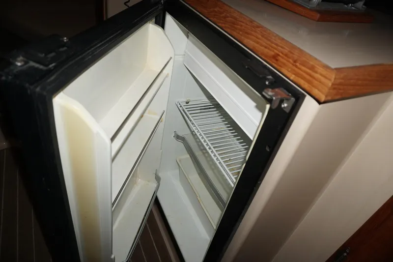  Yacht Photos Pics Open refrigerator inside 2013 Ranger Tugs S-31 boat, showcasing interior shelves.