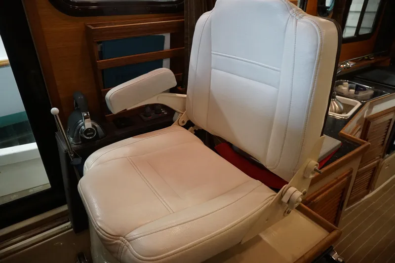  Yacht Photos Pics Captain's chair in 2013 Ranger Tugs S-31 boat interior, featuring white upholstery and control panel.