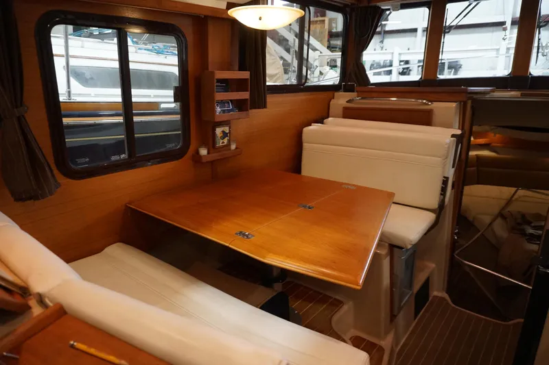  Yacht Photos Pics 2013 Ranger Tugs S-31 interior with wooden dining table and cushioned seating.