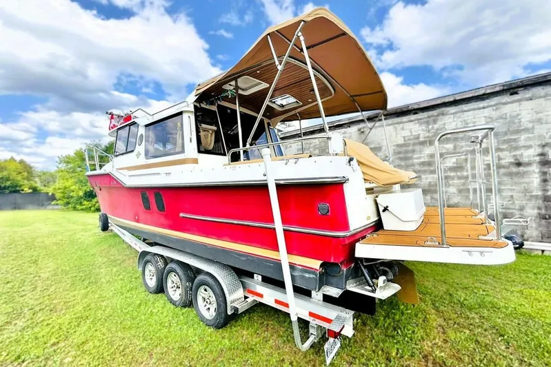  Yacht Photos Pics 2017 Ranger Tugs R-29S boat on trailer, red hull, outdoor setting, blue sky.