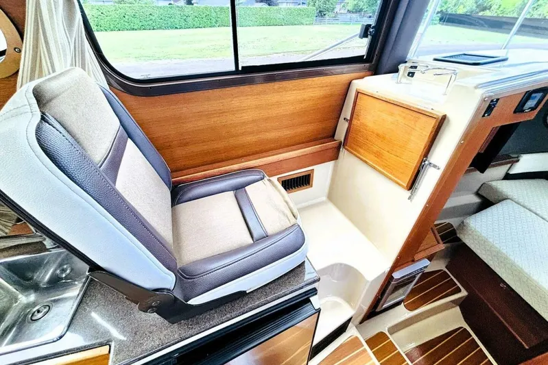  Yacht Photos Pics 2017 Ranger Tugs R-29S interior with cushioned seat, wooden accents, and window view.