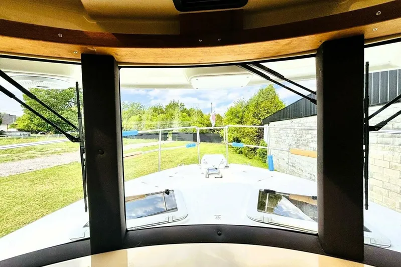  Yacht Photos Pics Interior view from 2017 Ranger Tugs R-29S boat, showcasing windshield and outdoor scenery.