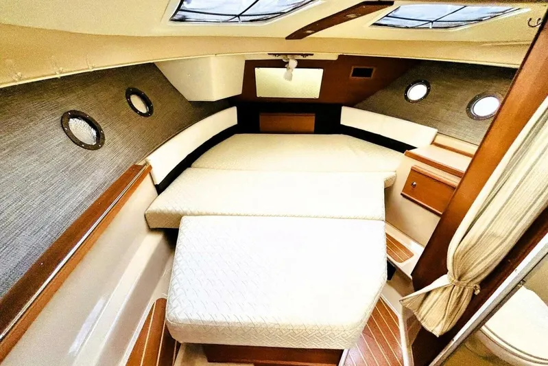  Yacht Photos Pics 2017 Ranger Tugs R-29S cabin interior with cozy bed and porthole windows.