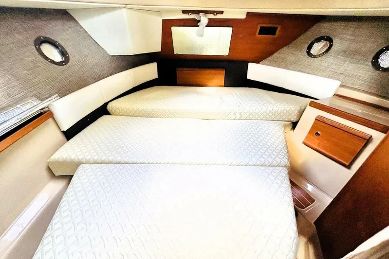  Yacht Photos Pics 2017 Ranger Tugs R-29S cabin interior with cozy sleeping area and porthole windows.