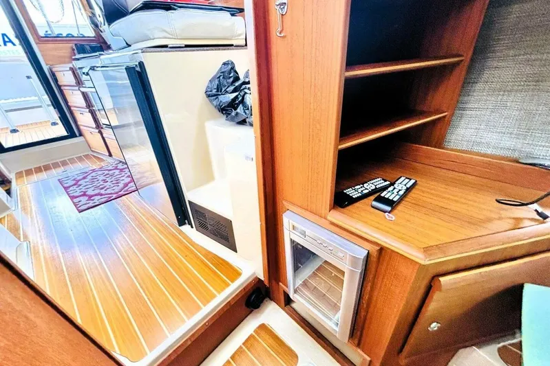  Yacht Photos Pics 2017 Ranger Tugs R-29S interior with wood finish, shelves, and mini fridge.