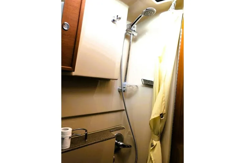  Yacht Photos Pics 2017 Ranger Tugs R-29S bathroom with shower, curtain, and wooden cabinetry.