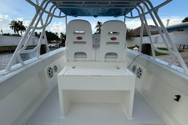  Yacht Photos Pics 2021 Marlin 39 CC boat interior with dual seats and speakers, docked by a canal.