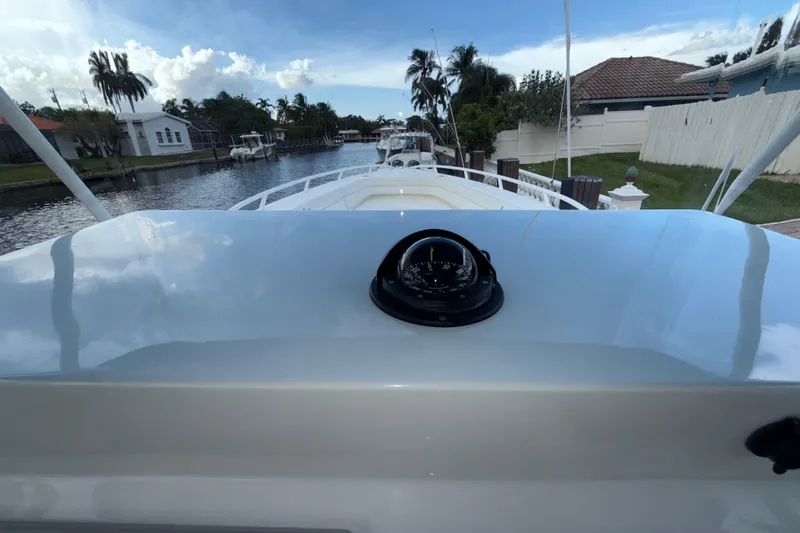  Yacht Photos Pics 2021 Marlin 39 CC boat with compass, docked in a scenic canal setting.