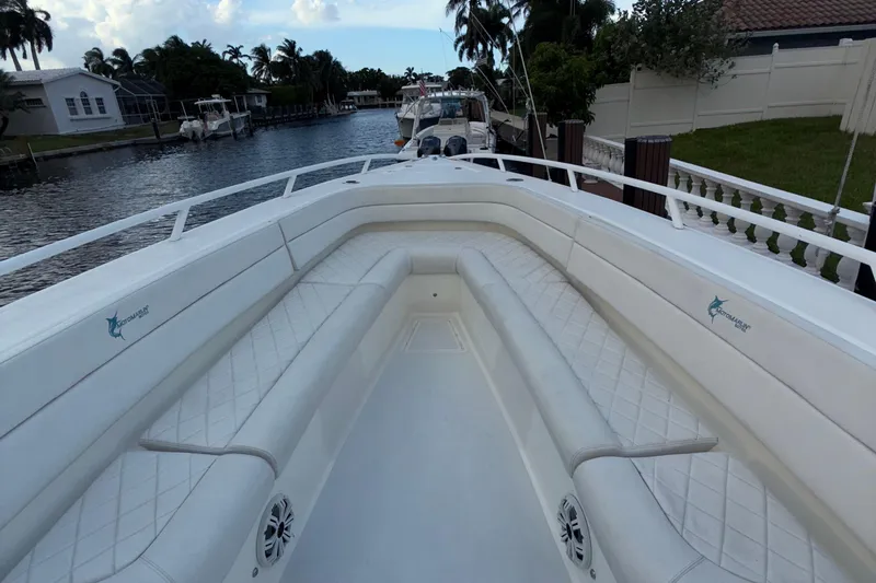  Yacht Photos Pics 2021 Marlin 39 CC boat interior with white cushioned seating, docked by a canal.