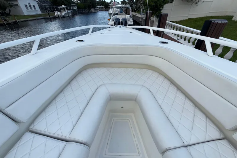  Yacht Photos Pics 2021 Marlin 39 CC boat with white cushioned seating, docked by a canal.