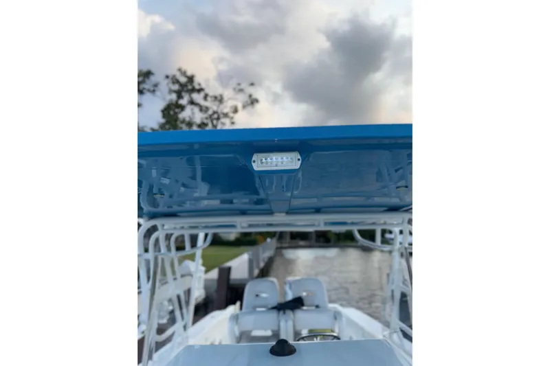  Yacht Photos Pics 2021 Marlin 39 CC boat with blue canopy, docked under cloudy sky.