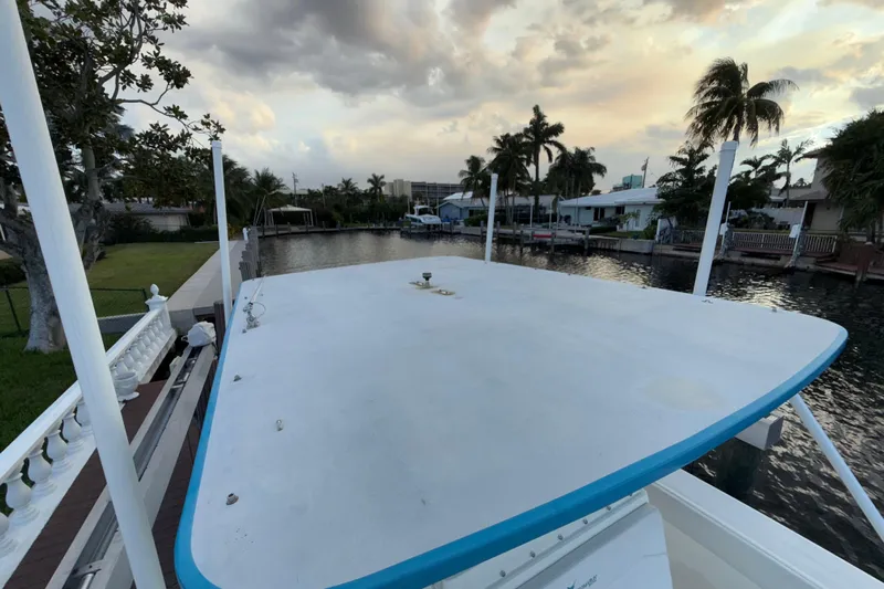  Yacht Photos Pics 2021 Marlin 39 CC boat docked by a canal at sunset, surrounded by palm trees.
