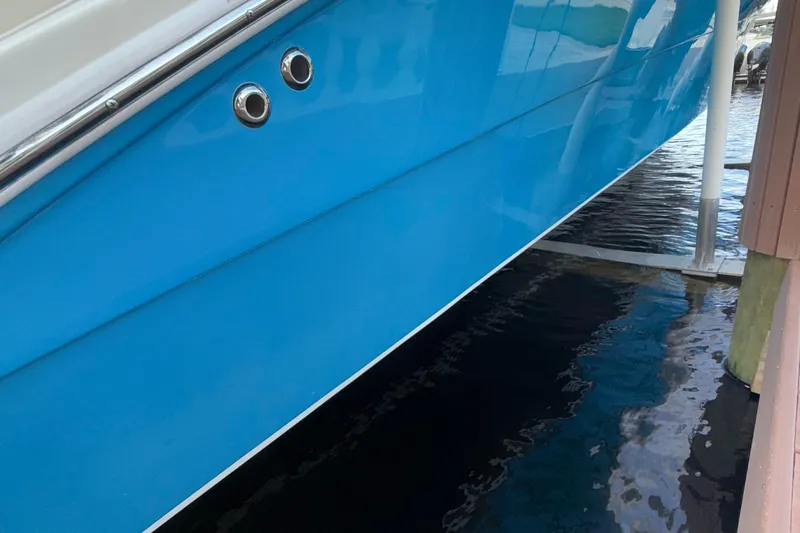  Yacht Photos Pics Blue hull of 2021 Marlin 39 CC boat docked above water.
