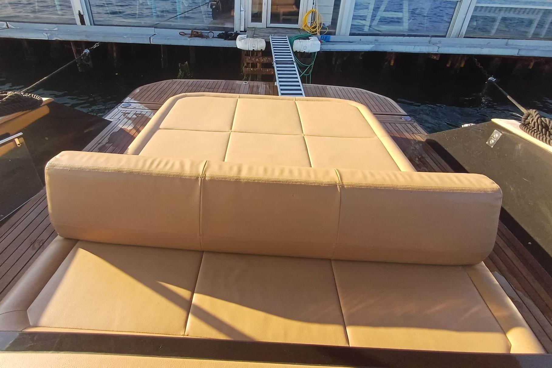 Luxurious tan leather seating on 2024 Focus Forza 37 yacht, docked by the water.