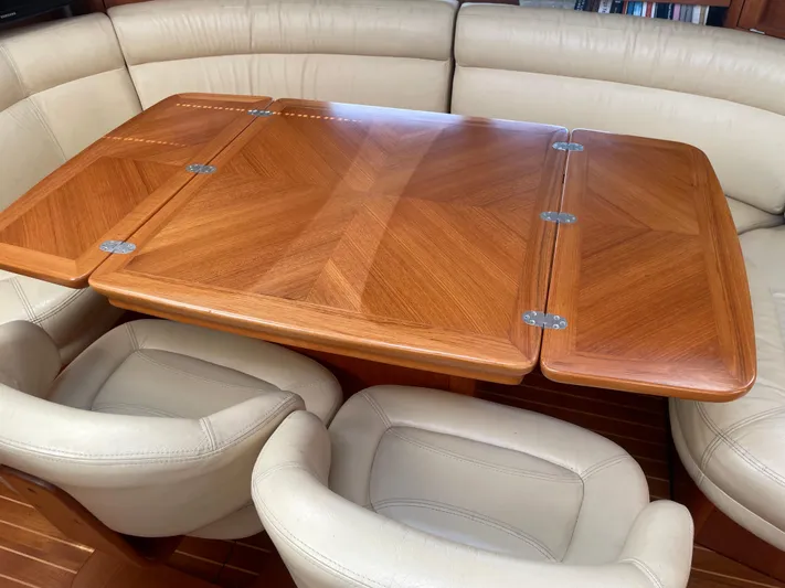 Jethro Yacht Photos Pics Luxurious interior of 2003 Jeanneau Sun Odyssey 54 DS with elegant wooden table and leather seating.