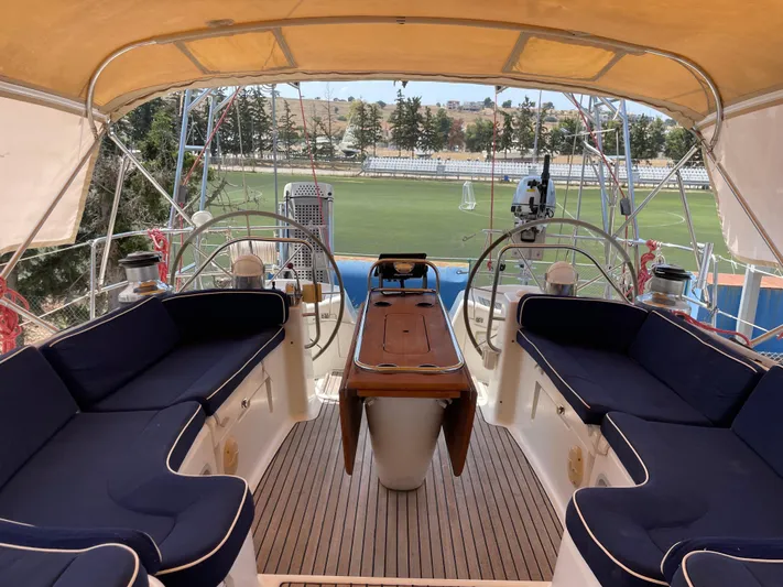 Jethro Yacht Photos Pics Cockpit of 2003 Jeanneau Sun Odyssey 54 DS sailboat with blue seating and wooden table.