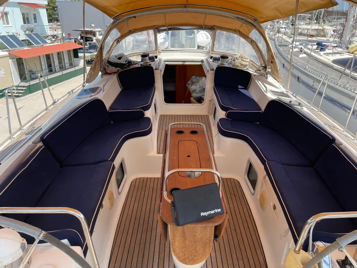 Jethro Yacht Photos Pics Spacious cockpit of 2003 Jeanneau Sun Odyssey 54 DS with navy cushions and wooden table.