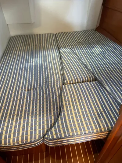 Jethro Yacht Photos Pics Cabin bed with blue checkered cushions on a 2003 Jeanneau Sun Odyssey 54 DS yacht.